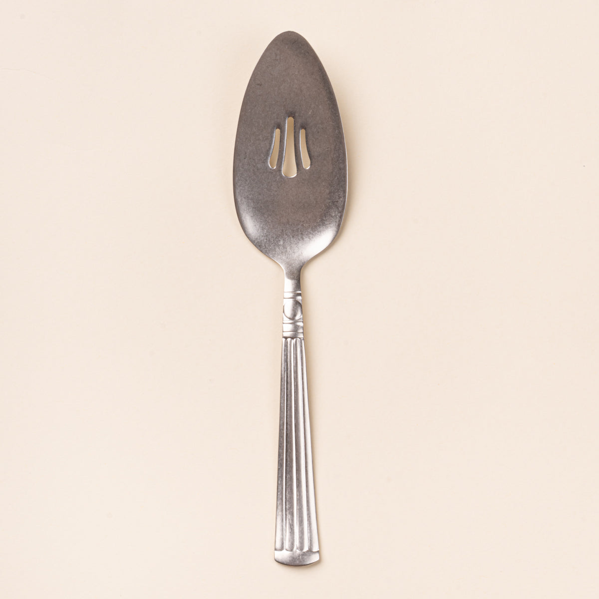 Vintage-inspired silver pie server with a slotted blade and fluted handle.
