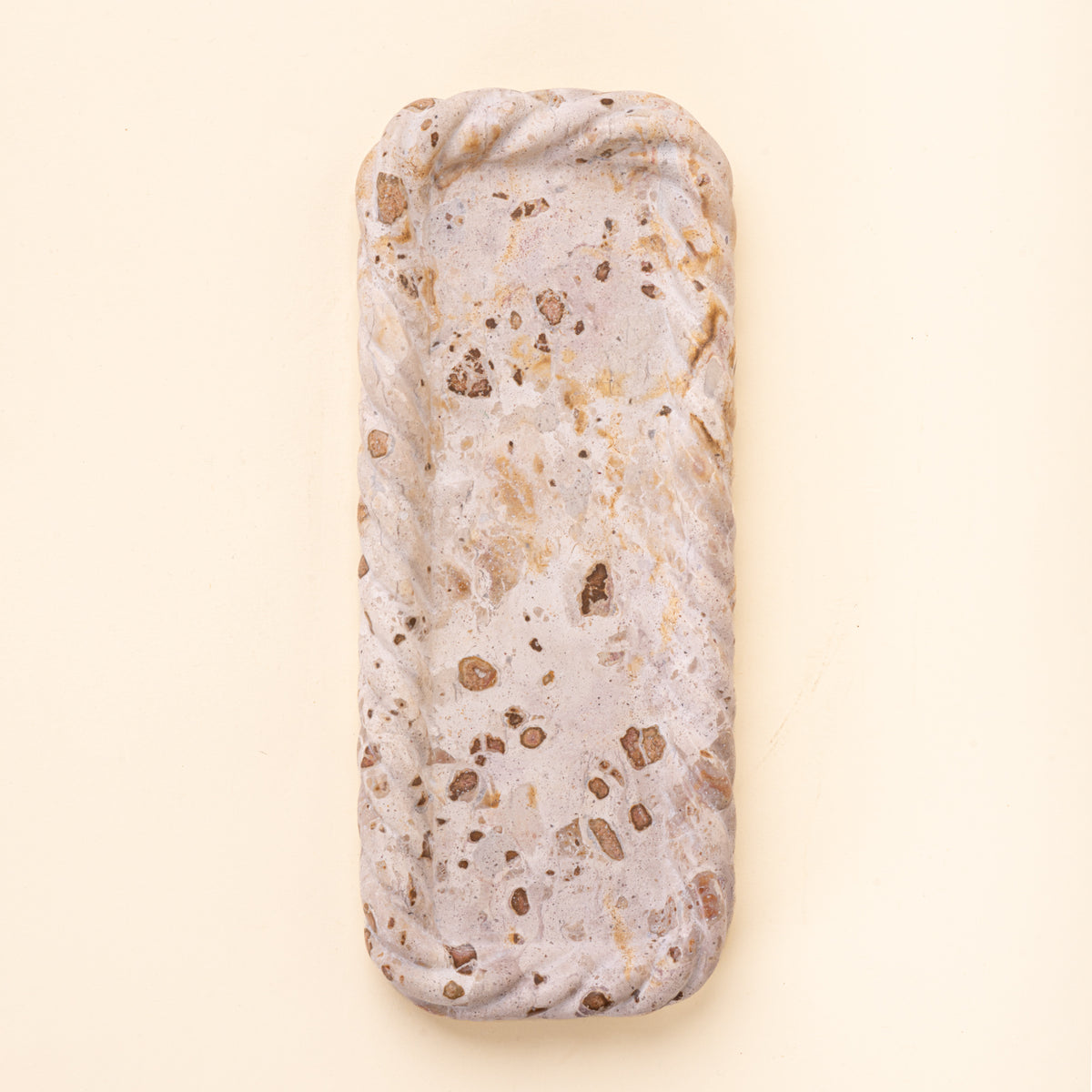 Rectangular cream and brown speckled stone tray with a shallow recessed center and irregular scalloped edges.