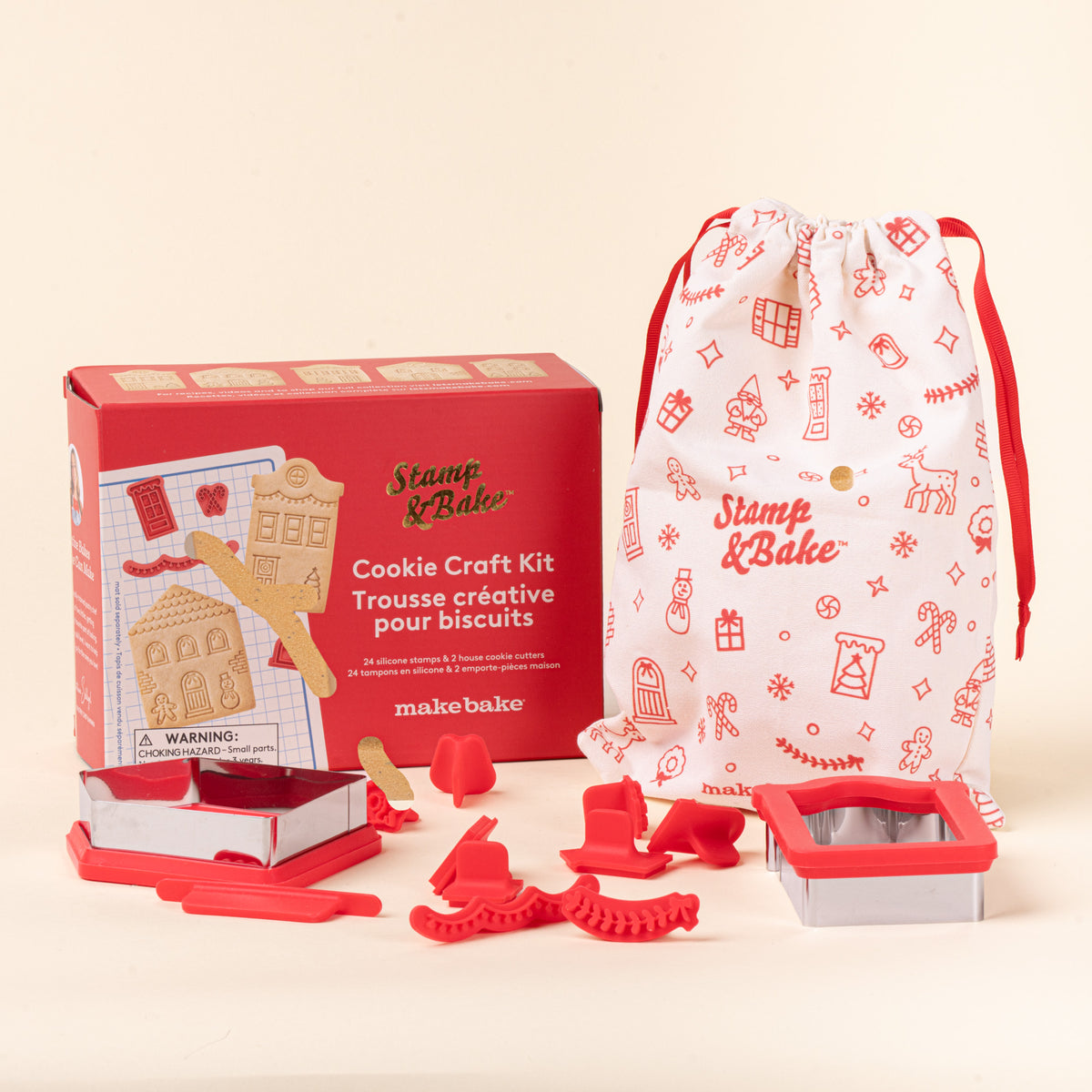 Stamp & Bake Cookie Craft Kit with red cookie cutters and stamps, a red box, and a white drawstring bag with holiday illustrations.