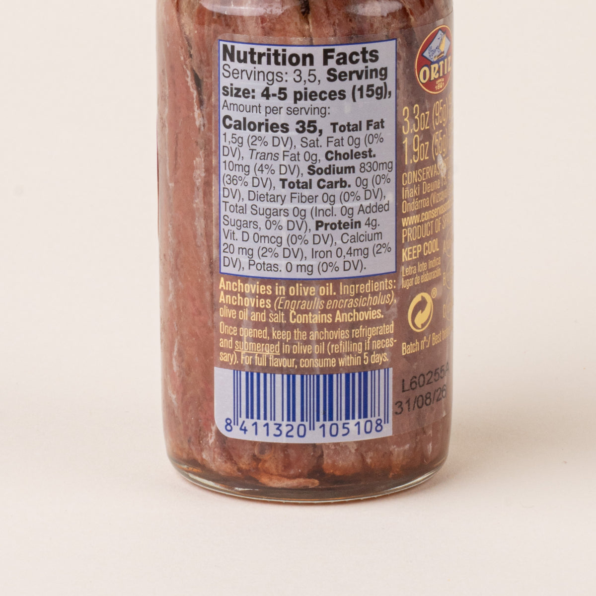 Close-up of the back of an Ortiz anchovy jar showing the nutrition facts, ingredients, storage instructions, and barcode.