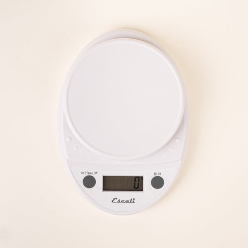 White digital kitchen scale with a round weighing platform and LCD display.
