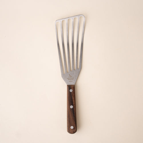 Slotted stainless steel spatula with a wooden handle.