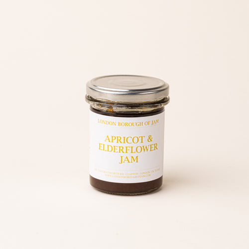 A glass jar with a white label of 'Apricot & Elderflower Jam'