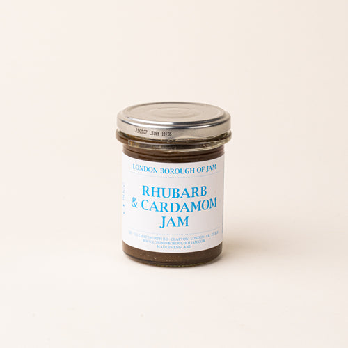 A glass jar with a white label of 'Rhubarb & Cardamom Jam'
