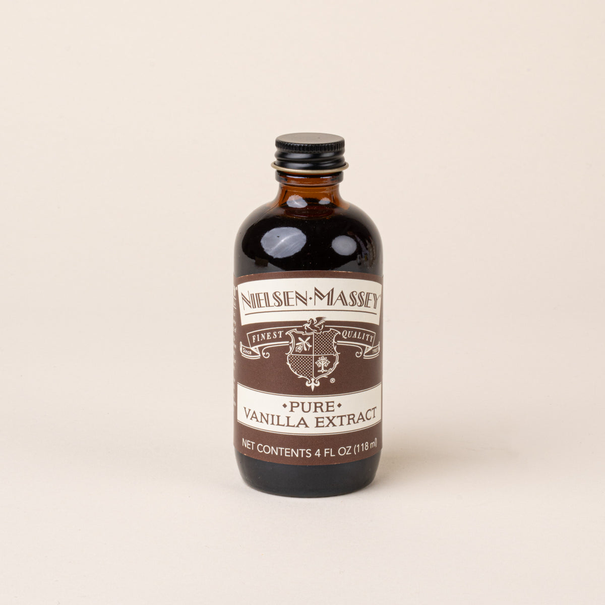 A glass brown jar of Pure Vanilla Extract with a brown and white label.