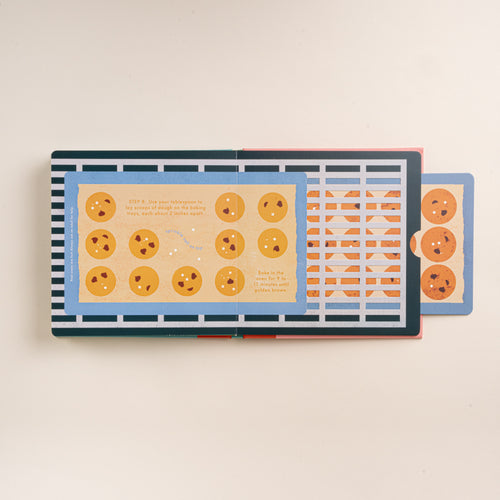 Open interactive cookie recipe book showing illustrated cookies on baking trays with a pull-out tab.