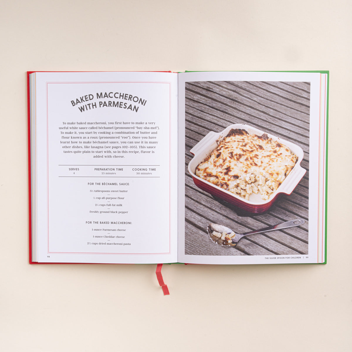 Open children’s cookbook showing a baked macaroni with Parmesan recipe and finished dish.