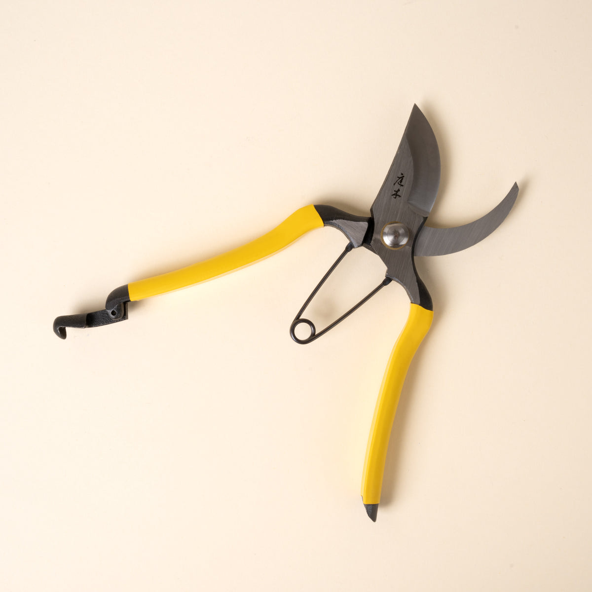 Open yellow-handled pruning shears with metal blades and spring mechanism, shown on a neutral background.