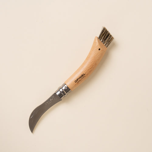 Wood-handled folding mushroom knife with curved blade and built-in brush on handle end.