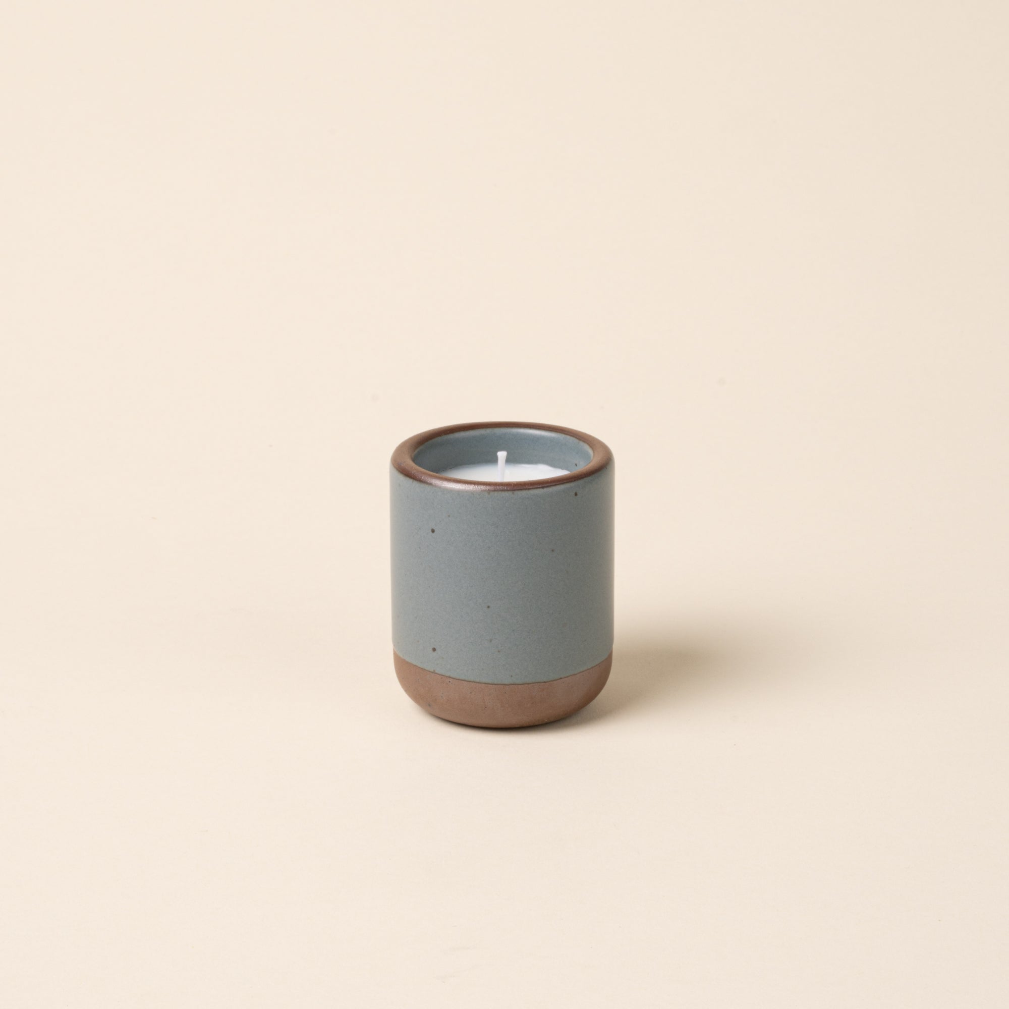 Small ceramic vessel in a blue-grey color with candle inside.
