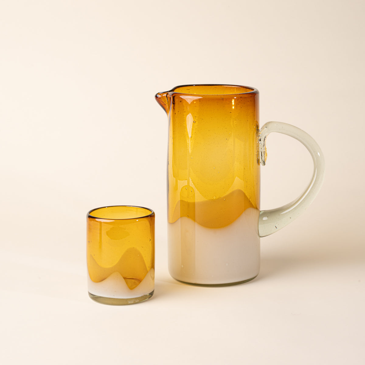 Amber and clear handblown glass pitcher with organic wave design with clear handle, with matching tumbler