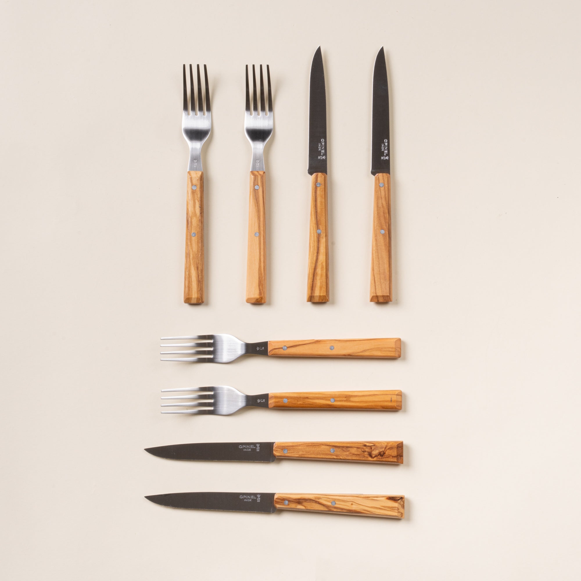 Set of 8 Opinel table knives and forks with wooden handles.