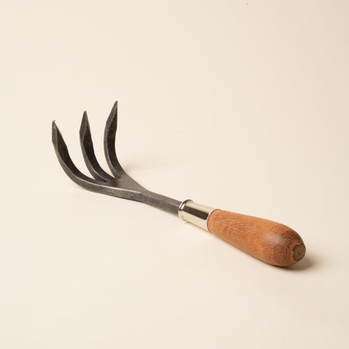 Handheld three-prong garden cultivator with a wooden handle.