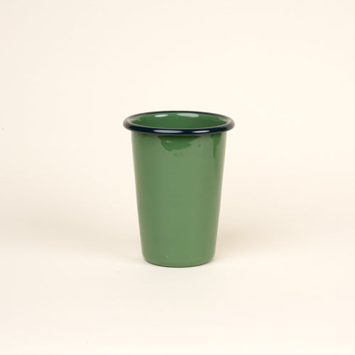 A tall green enamel tumbler with a dark rim, set against a soft beige background.