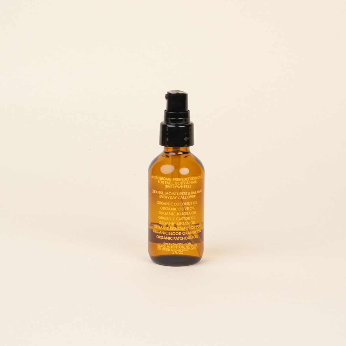 Bottle of organic body oil on a beige background