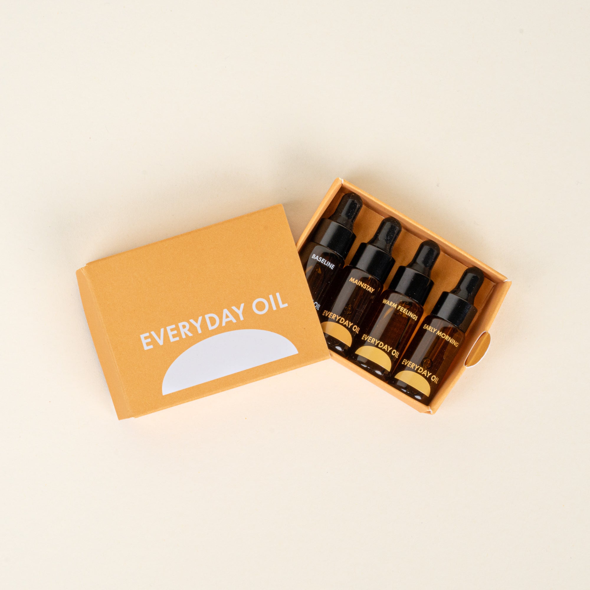 Box of 'Everyday Oil' dropper bottles on a beige background