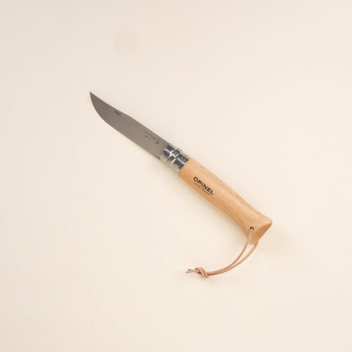 Wood-handled folding knife with stainless steel blade and leather lanyard, shown on a neutral background.