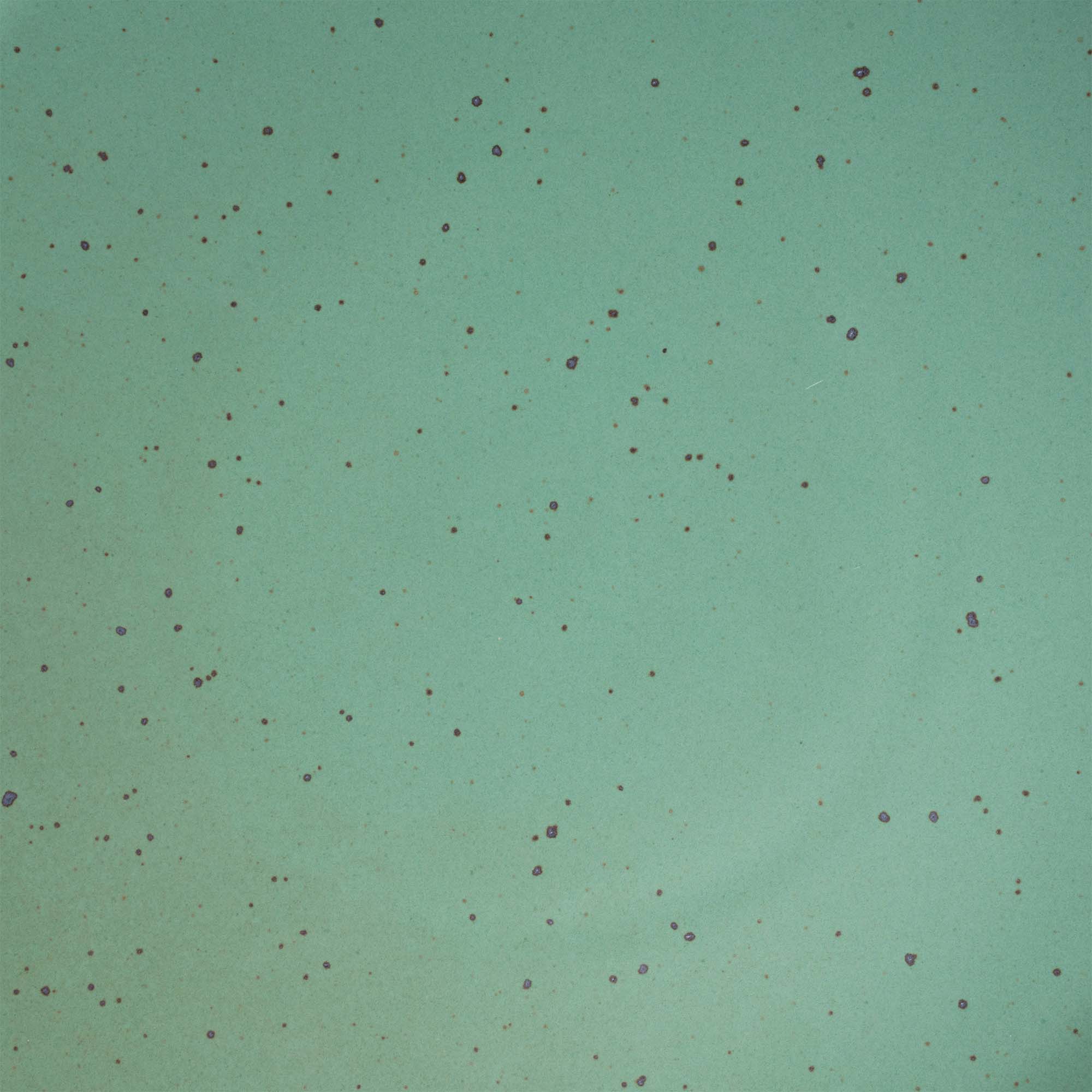 A close up of a viridian green speckled ceramic glaze