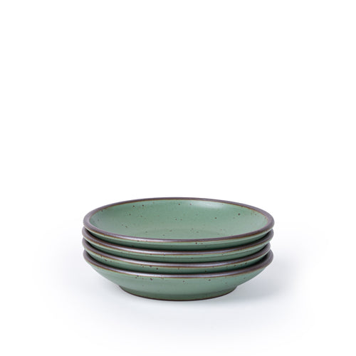 A stack of 4 small ceramic plates with a curved bowl edge in a cool green color featuring iron speckles and an unglazed rim.