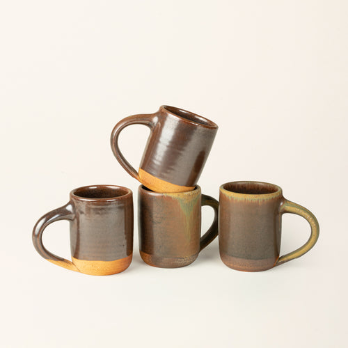 Four  handmade ceramic mug with a wood fired earthy muddy glaze with an unglazed base.