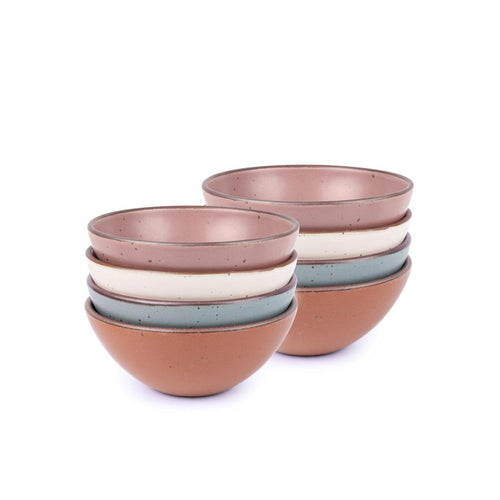 A stack of 8 medium sized rounded ceramic bowls in a cool terracotta, warm off-white, blue-grey and dusty mauve pink colors featuring iron speckles and an unglazed rim
