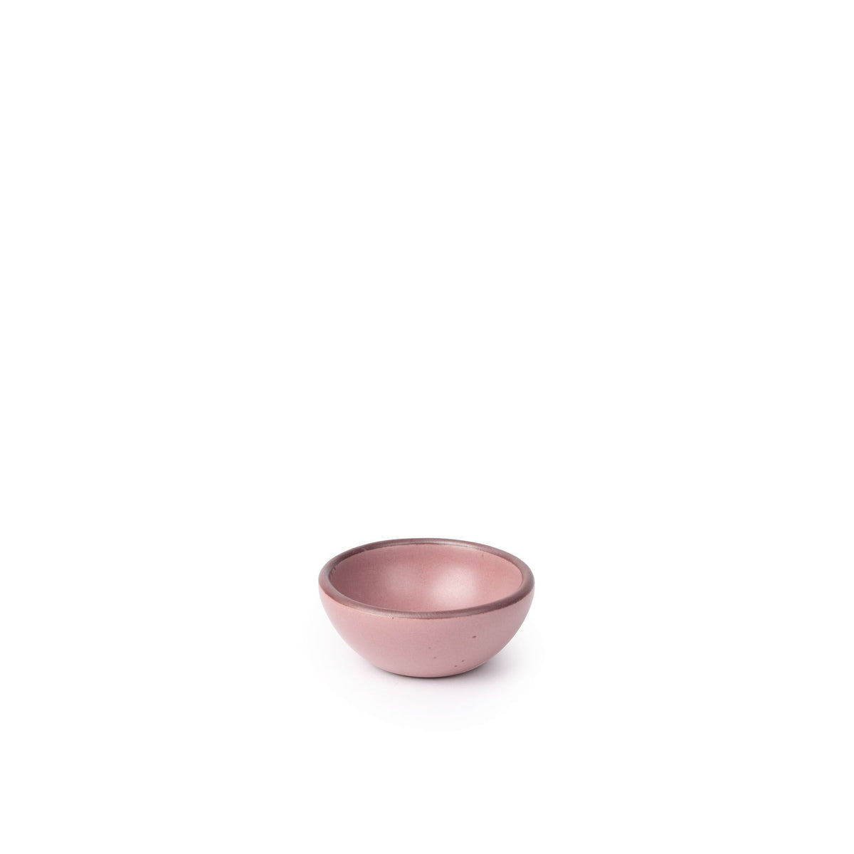 A tiny rounded ceramic bowl in a dusty mauve pink color featuring iron speckles and an unglazed rim