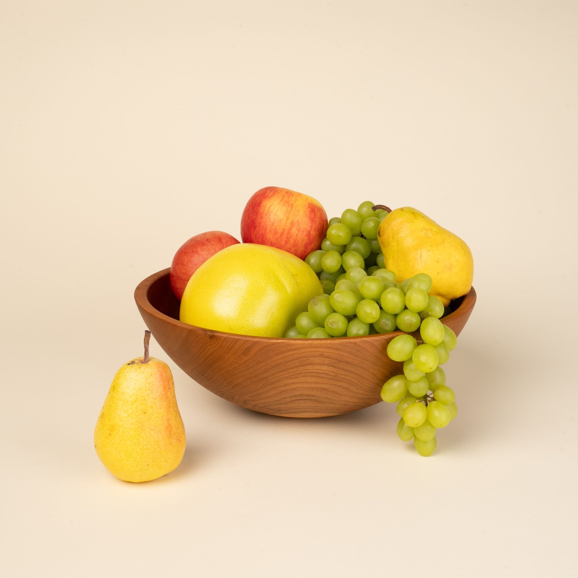 Green grapes, pears, apples in a large cherry wood bowl