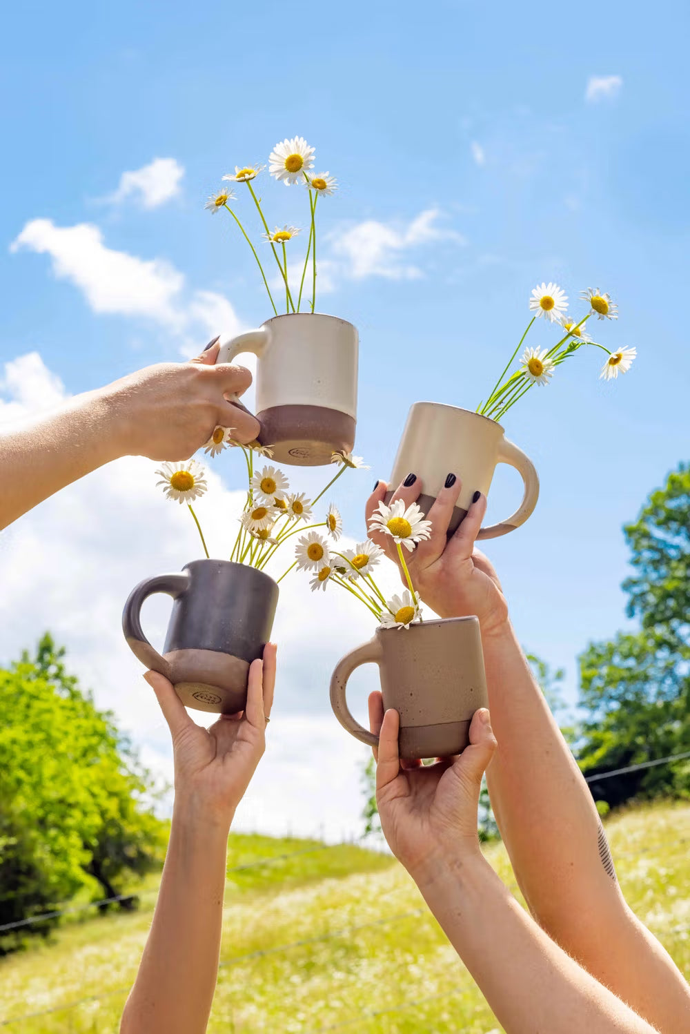 A hand holding an eggshell everyday bowl filled with pears