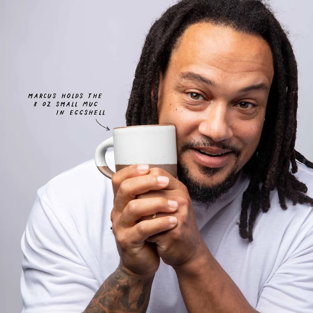 Marcuz holds the 8 oz Small Mug in Eggshell up to his cheek