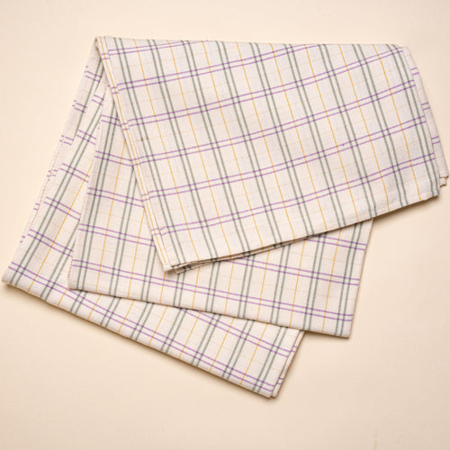 A plaid tablecloth with lines of purple, yellow, and dark teal.