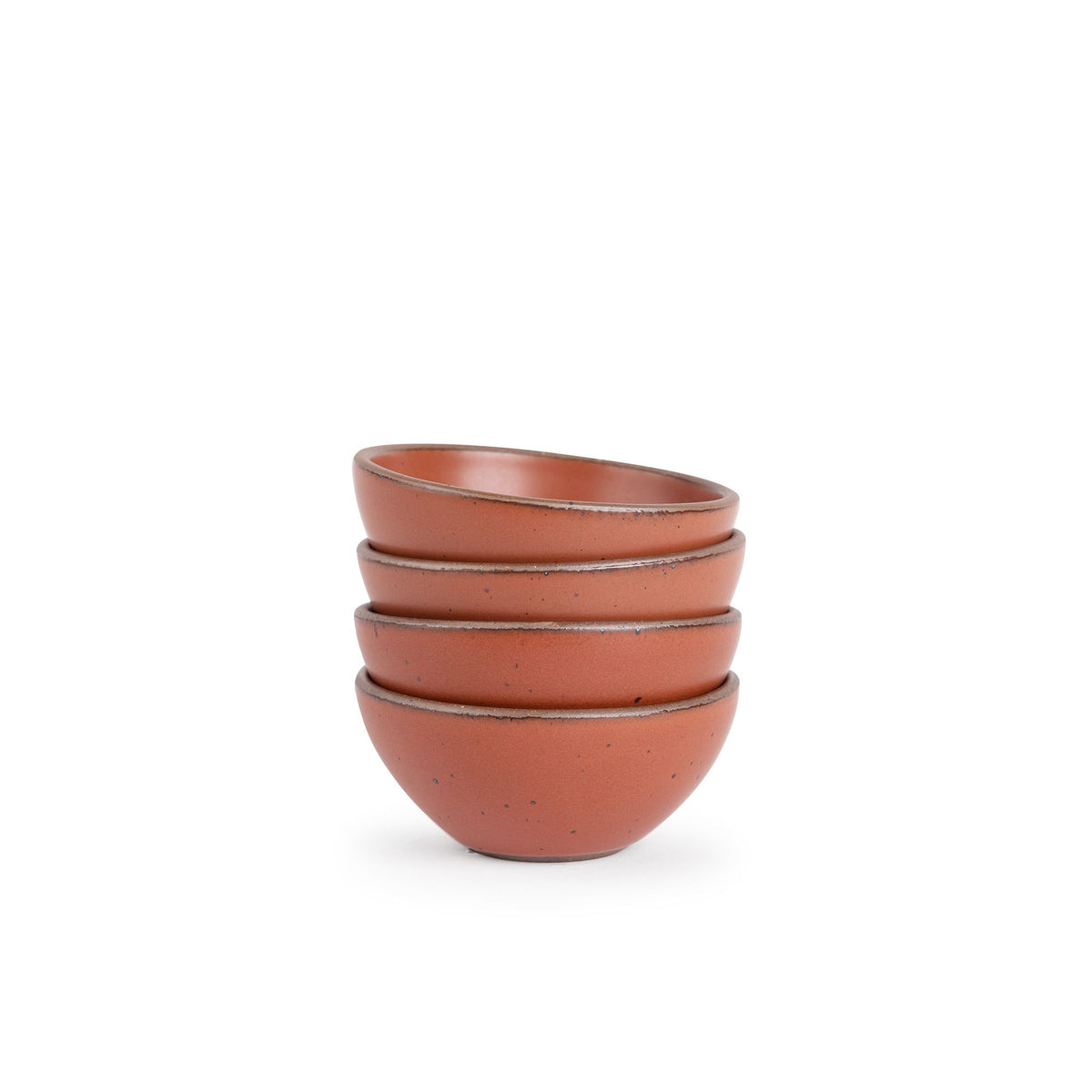 A stack of 4 small dessert sized rounded ceramic bowls in a cool burnt terracotta color featuring iron speckles and an unglazed rim