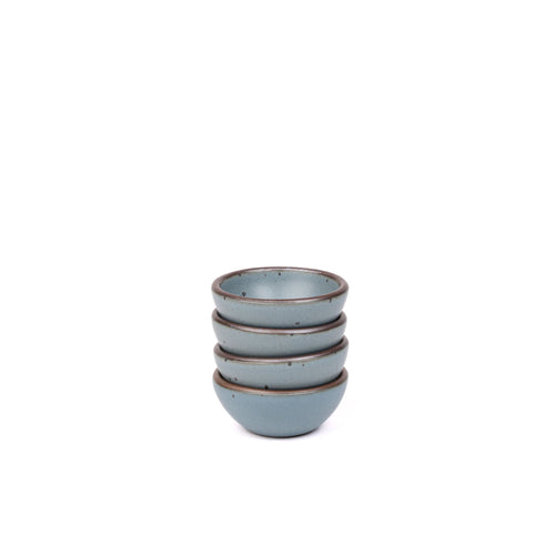 A stack of 4 tiny rounded ceramic bowls in a blue-grey color featuring iron speckles and an unglazed rim