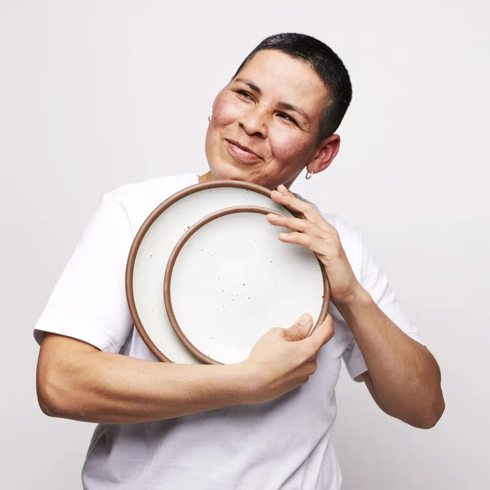 East Fork employee lovingly holds two plates in Eggshell