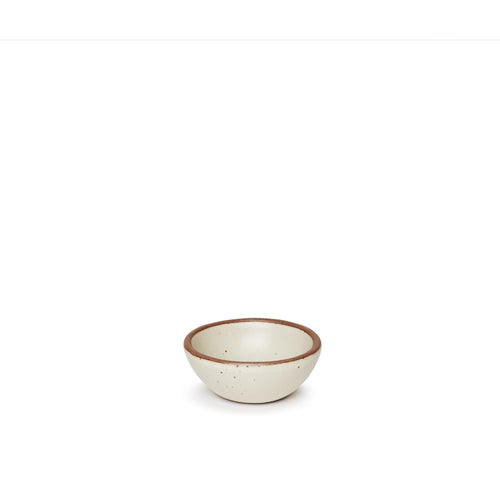A tiny rounded ceramic bowl in a warm, tan-toned, off-white color featuring iron speckles and an unglazed rim