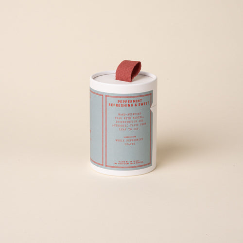 RAAZI Peppermint tea tin with pale blue label and red pull tab, photographed on a soft neutral background