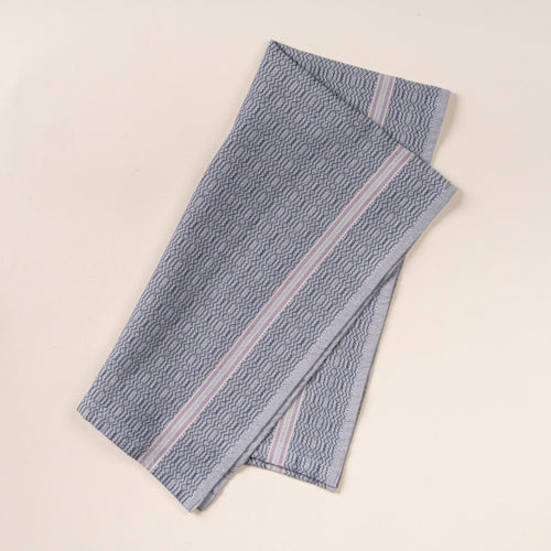 Grey kitchen towel with a subtle textured pattern and slim striped accent, folded neatly on a clean neutral background.