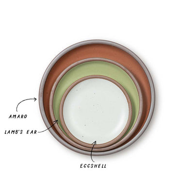 3 stacked ceramic plates in a calming sage, a terracotta, and a white color