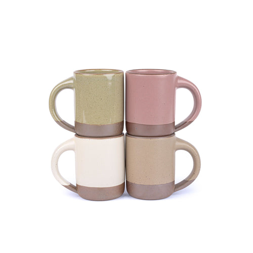 Four medium sized ceramic mugs with handles in a reflective dappled grey-green, warm off-white, warm pale brown, and dusty mauve pink colors featuring iron speckles and unglazed rim