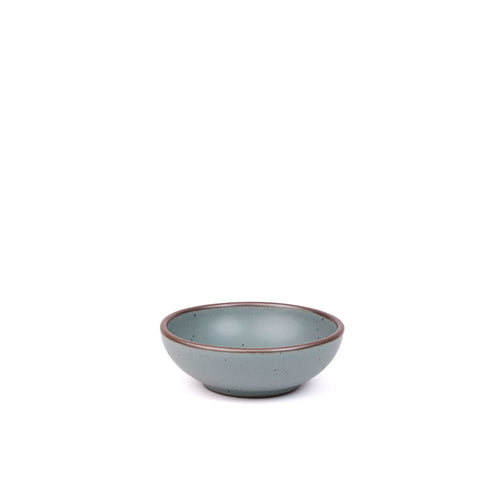 A small shallow ceramic bowl in a blue-grey color featuring iron speckles and an unglazed rim
