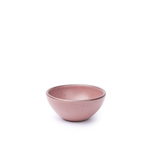 A small dessert sized rounded ceramic bowl in a dusty mauve pink color featuring iron speckles and an unglazed rim