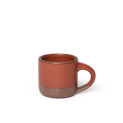 A ceramic mug with a compact form and study handle in a cool terracotta color with a matte finish.
