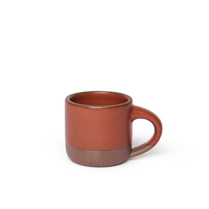 A ceramic mug with a compact form and study handle in a cool terracotta color with a matte finish.