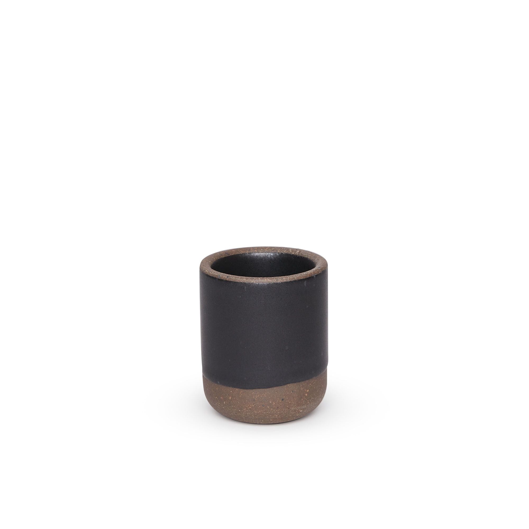 A small, short ceramic mug cup in a graphite black color featuring iron speckles and unglazed rim and bottom base.