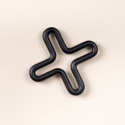 Black wavy trivet shaped like a four-point star on a light neutral background.