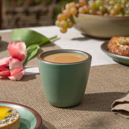 A handleless ceramic cup with a gently tapered form in a viridian green glaze with a matte finish.