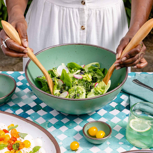 A deep ceramic bowl with a wide rim for mixing or serving in a viridian green glaze with a matte finish.