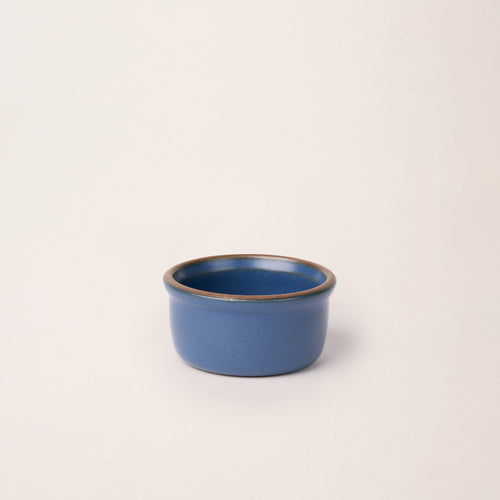 Small ceramic ramekin in a cool blue color with an unglazed rim