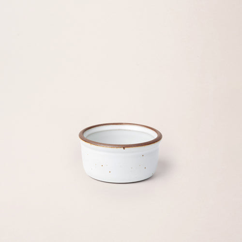 Small ceramic ramekin in a cool white color with an unglazed rim