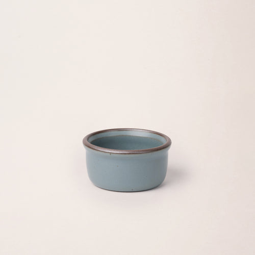 Small ceramic ramekin in a blue-grey color with an unglazed rim