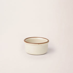 Small ceramic ramekin in a warm off-white color with an unglazed rim